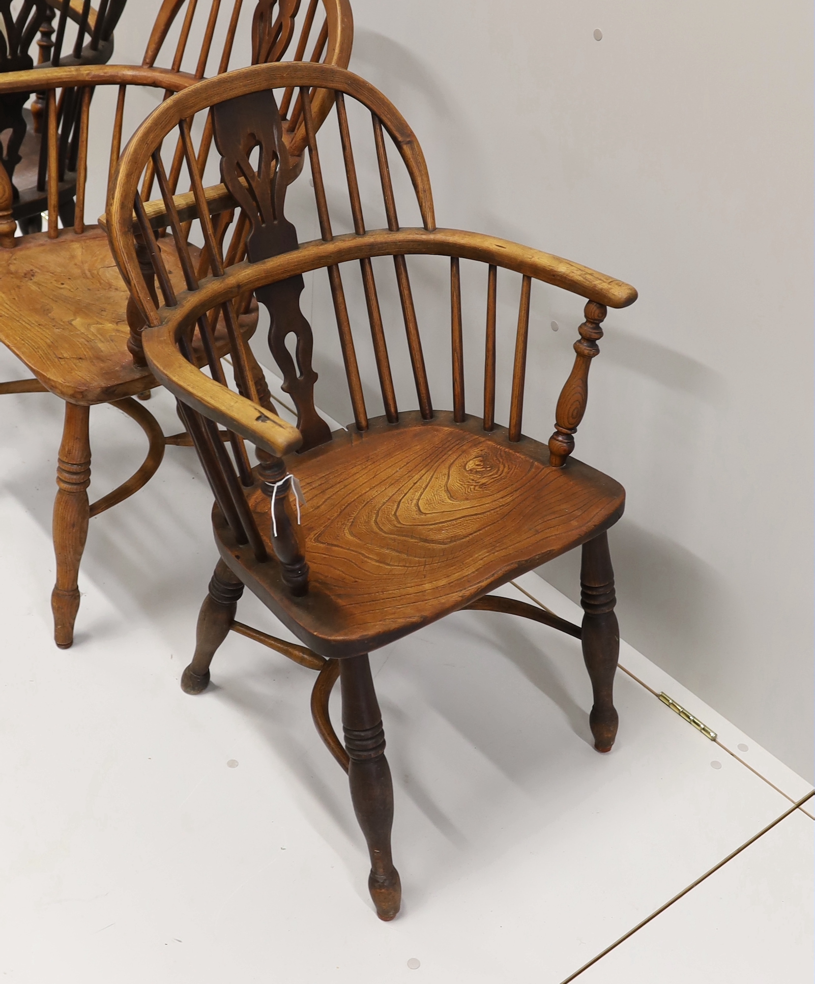 Three 19th century Nottingham area Windsor ash and elm elbow chairs with crinoline stretchers, largest width 55cm, depth 39cm, height 95cm